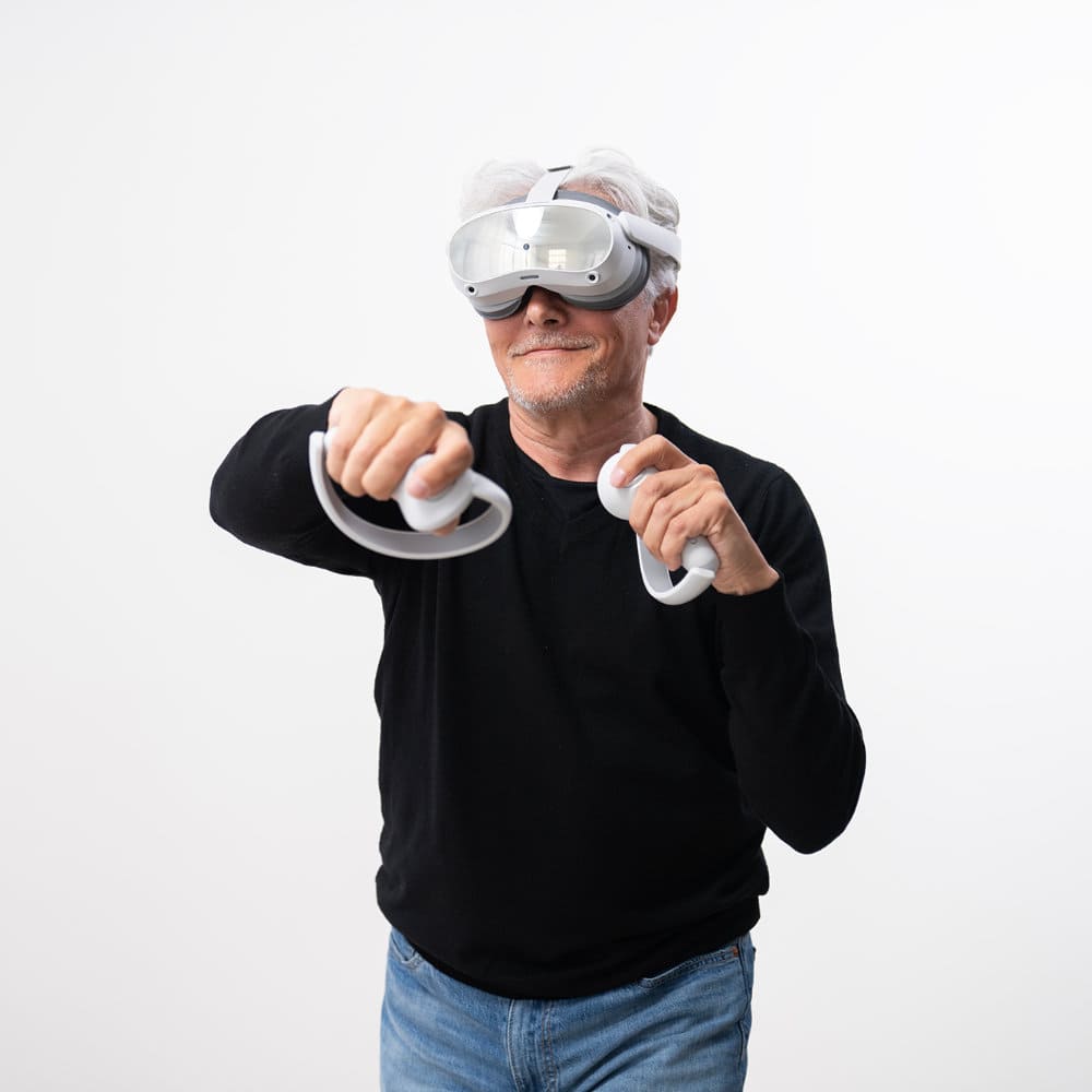 Senior man making movements with his arms while practicing occupational therapy with virtual reality