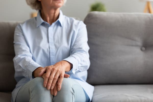 Senior woman sitting on sofa thoughtful