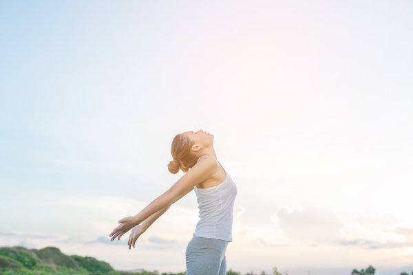 Woman practicing physical activity outdoors feeling liberated and relaxed