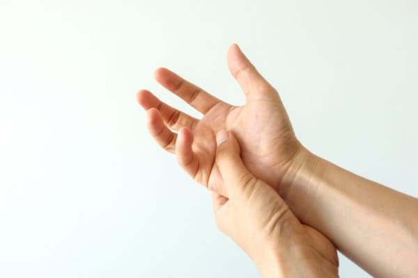 two hands doing squeezing movement to treat movement disorders