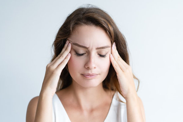 Woman with worried expression, hands on forehead, with stress and anxiety